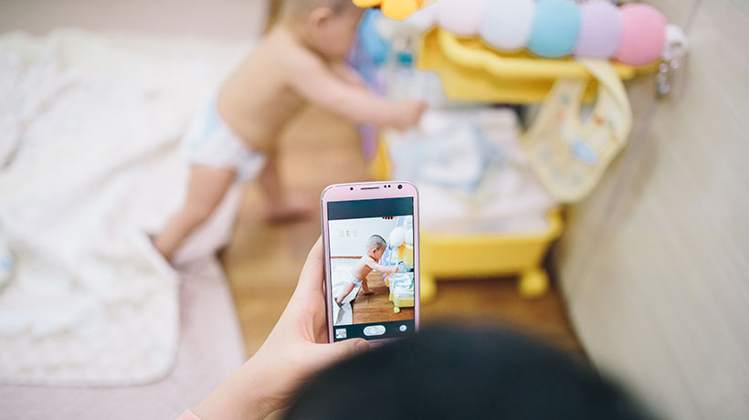 A parent taking a picture of their toddler